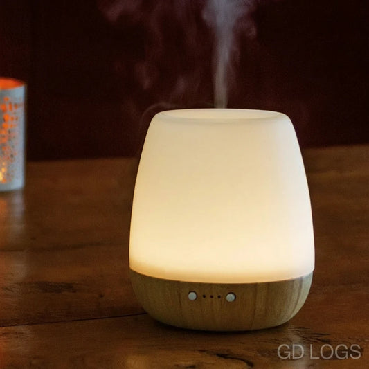 White diffuser emitting steam on a wooden surface with a dark background
